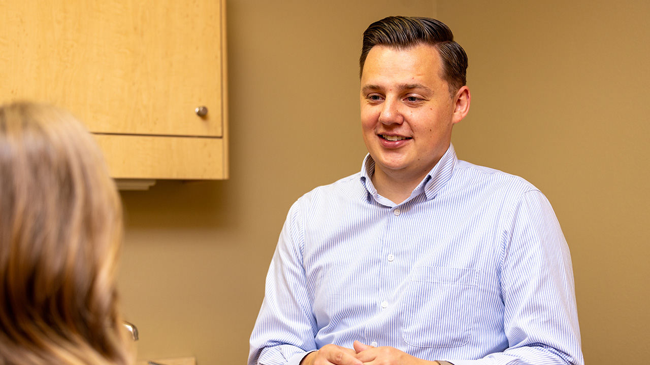 Dr. Dallin Thueson talking with a patient before treatment